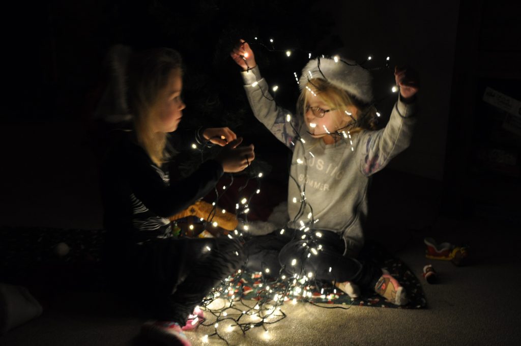 dochters in de weer met kerstlampjes